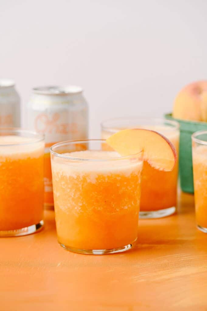 frozen ginger peach bellinis in a glass with a peach slice