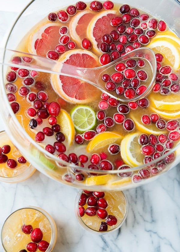 punch bowl filled with holiday citrus sangria garnished with citrus slices and cranberries